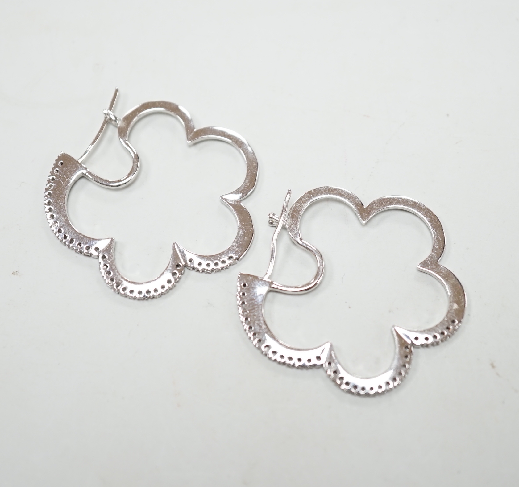 A pair of modern 750 white metal and diamond chips set 'cloud' shaped earrings, 37mm, 10.4 grams.